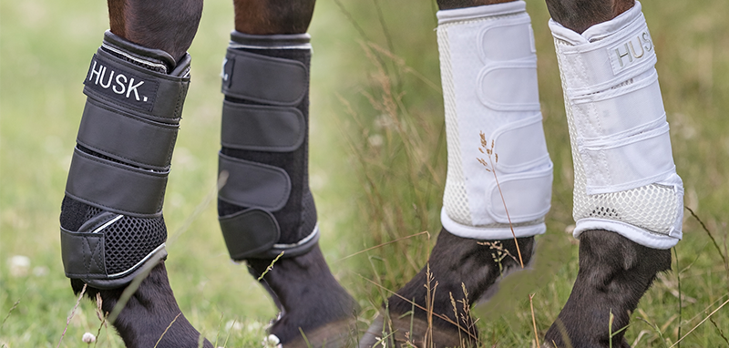 A pair of black and a pair of white protective horse boots by The Husk